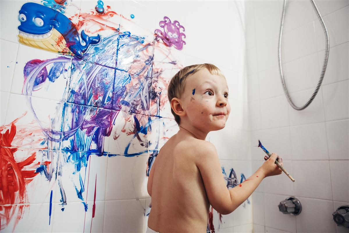 Forventningsfull smårolling blir fersket i å male ned veggen på badet med maling i ulike farger - Klikk for stort bilde