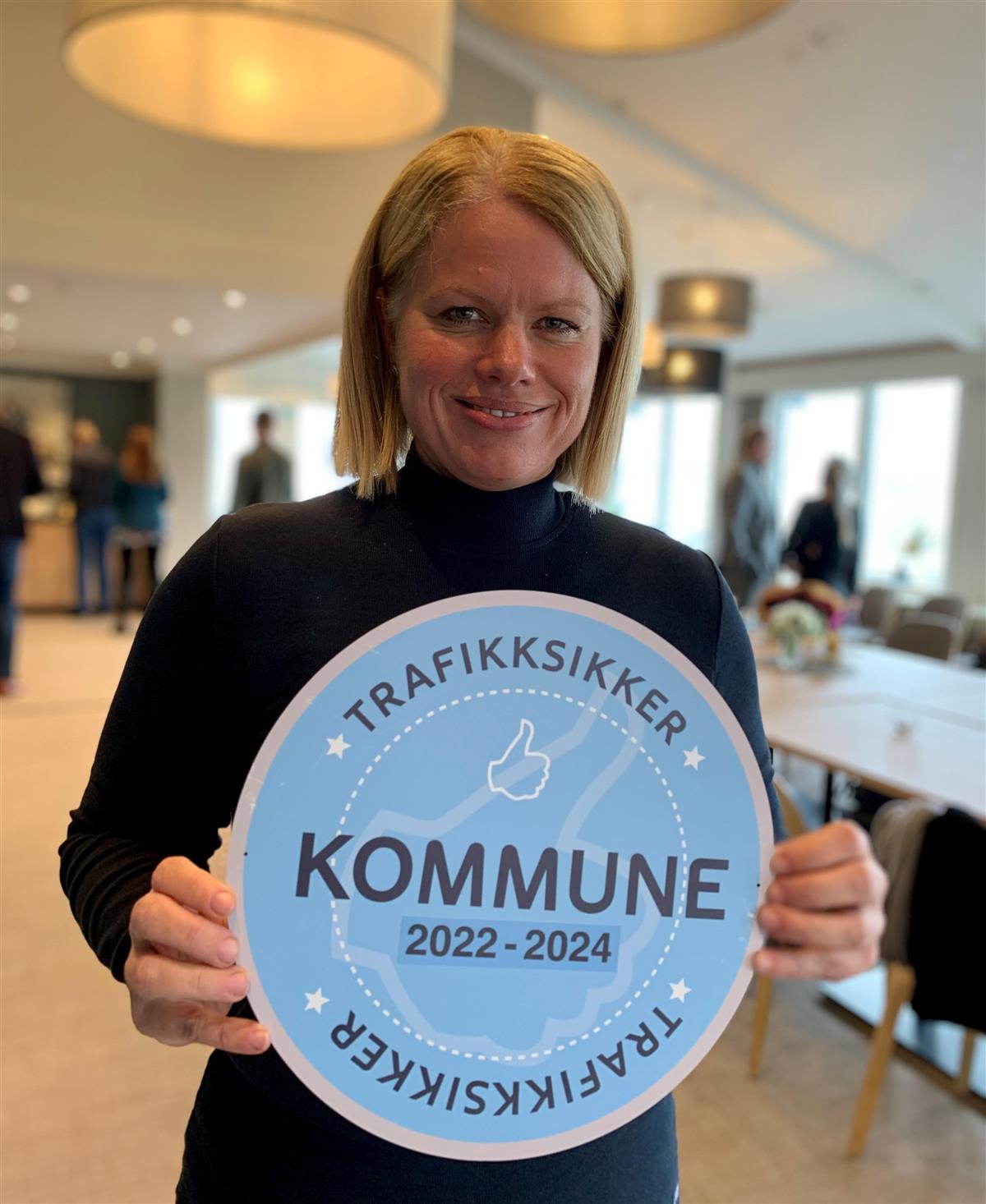 Britt Svendsen med skilt "Trafikksikker kommune" - Klikk for stort bilde